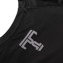 Load image into Gallery viewer, Tricks and Traps logo on a black and silver rash guard